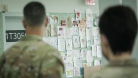 在费城附近的一个撤离者处理设施中，美国陆军人员看着由阿富汗儿童涂色的墙壁