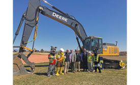 men posing in front of construction digger