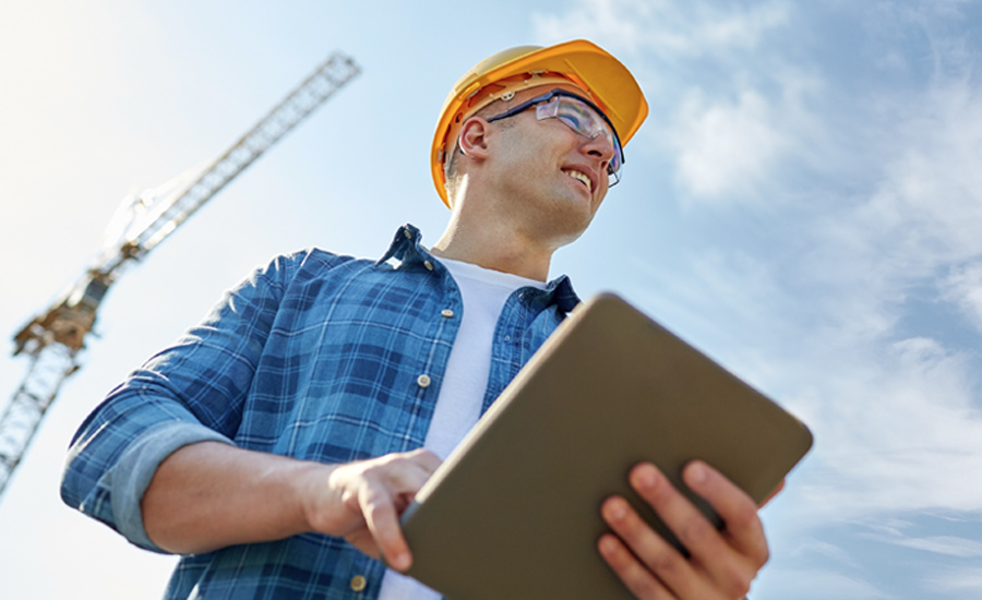 construction worker w/tablet, crane in background