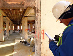 Carlos Romero takes measurements to see if the header needs to be cut on this first-floor hallway. The former hospital’s 8-ft-wide corridors will remain intact and will be incorporated into the new design.