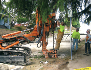 Crews pump low-density concrete into tunnel voids found by drilling.